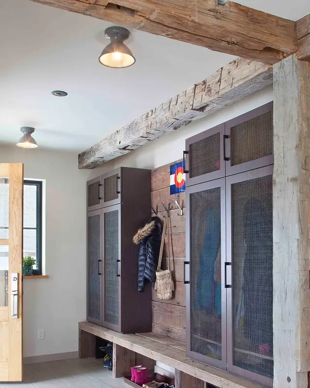 Functional mudroom with built-in lockers, rustic wood finishes, and exposed timber detail.