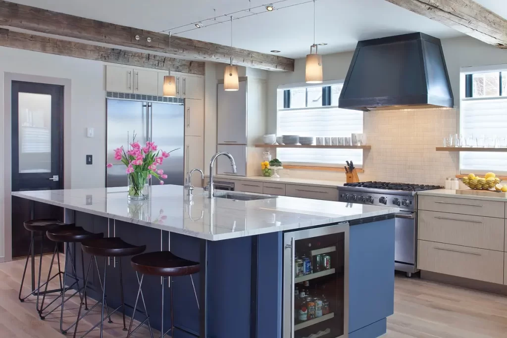 Chef’s kitchen with stainless appliances, open shelving, and statement range hood in a mountain-modern home.